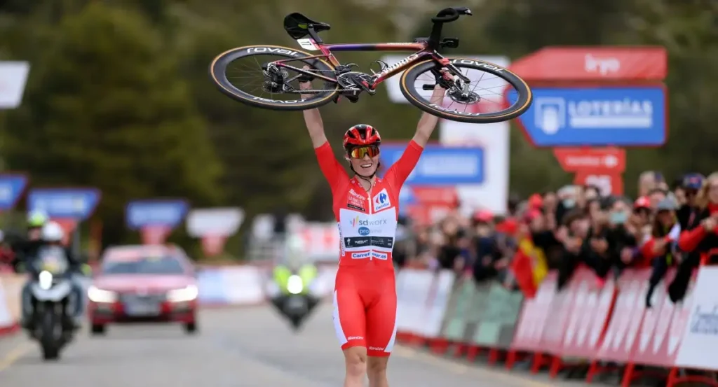 Vollering alzando la bicicleta en señal de victoria en La Vuelta femenina 2024