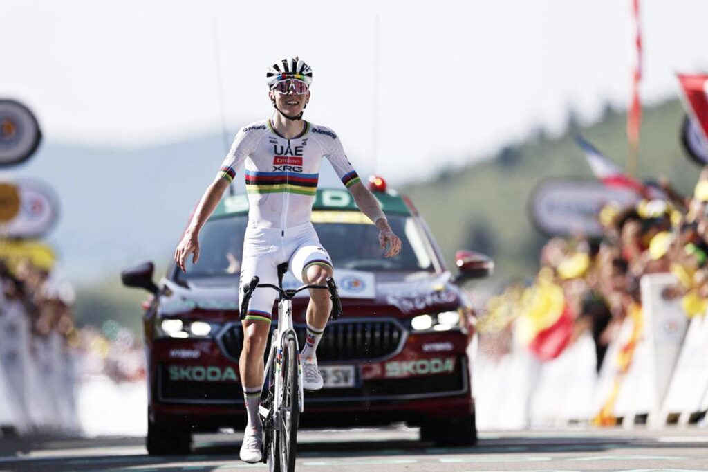 Tadej Pogačar cruza la meta con los brazos en alto, vistiendo el maillot arcoíris, en una victoria que confirma su dominio absoluto en la segunda semana del Tour 2025.